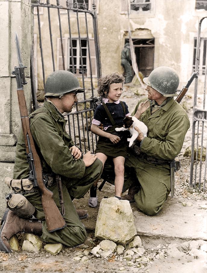  1944: American soldiers comfort a little girl and her puppy after the invasion of Normandy, Colleville-sur-Mer. Today, almost 10,000 war graves lie in the Normandy American Cemetery and Memorial in Colleville-sur-Mer.