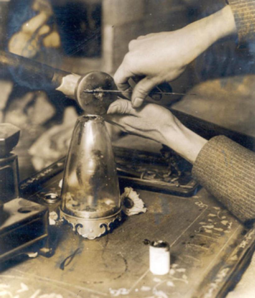  A rare photo showing a close-up of a user preparing a 'pill' of opium for the pipe