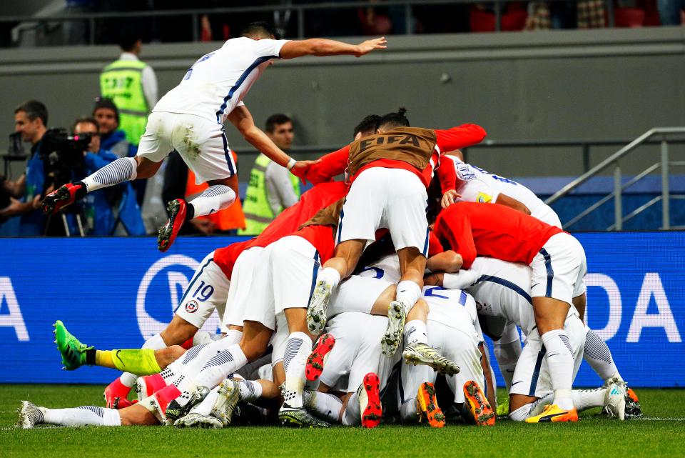  The Chilean squad bundle together after Claudio Bravo produced a masterclass in the penalty shootout