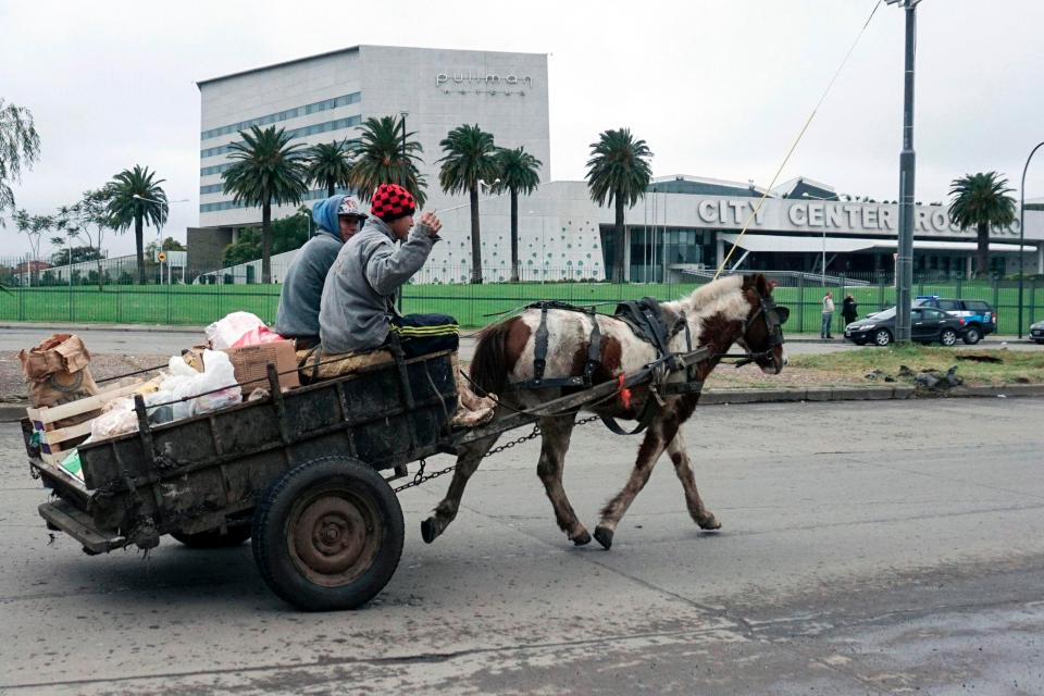  Locals ride a horse and cart as they pass the venue for Lionel Messi's wedding