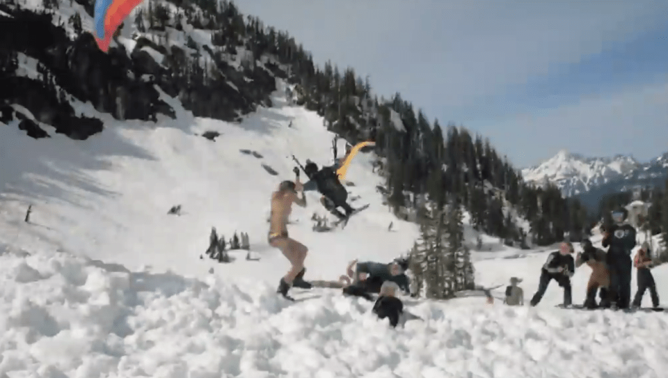 Footage shows the moment a bikini-clad woman was almost wiped out by a parachute skier who was trying to land on a slope