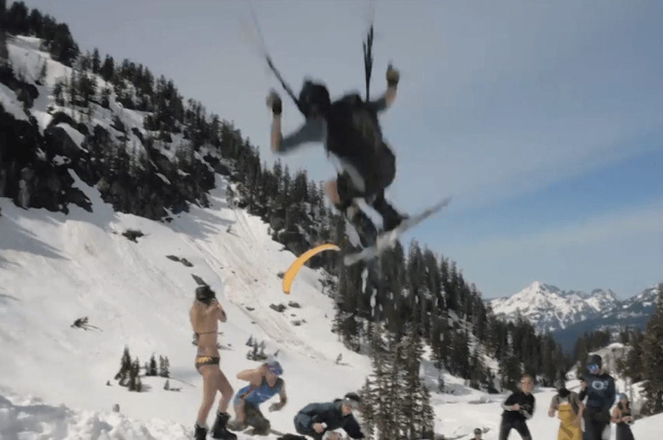 The girl appeared to have been trying to film the stunt parachute skiers