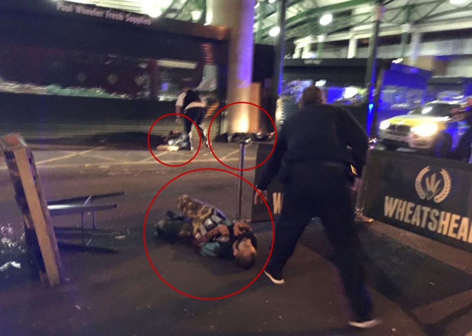 The three terrorists are pictured lying on the ground after being taken out by armed cops