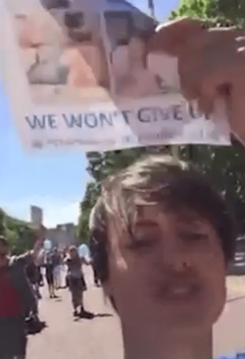  A protester holds a sign which reads 'We won't give up'