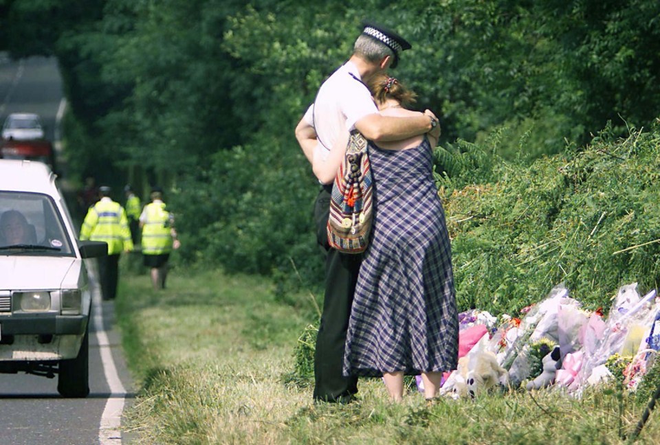 Local resident expresses the heartbreak of a nation as she is comforted by a police officer