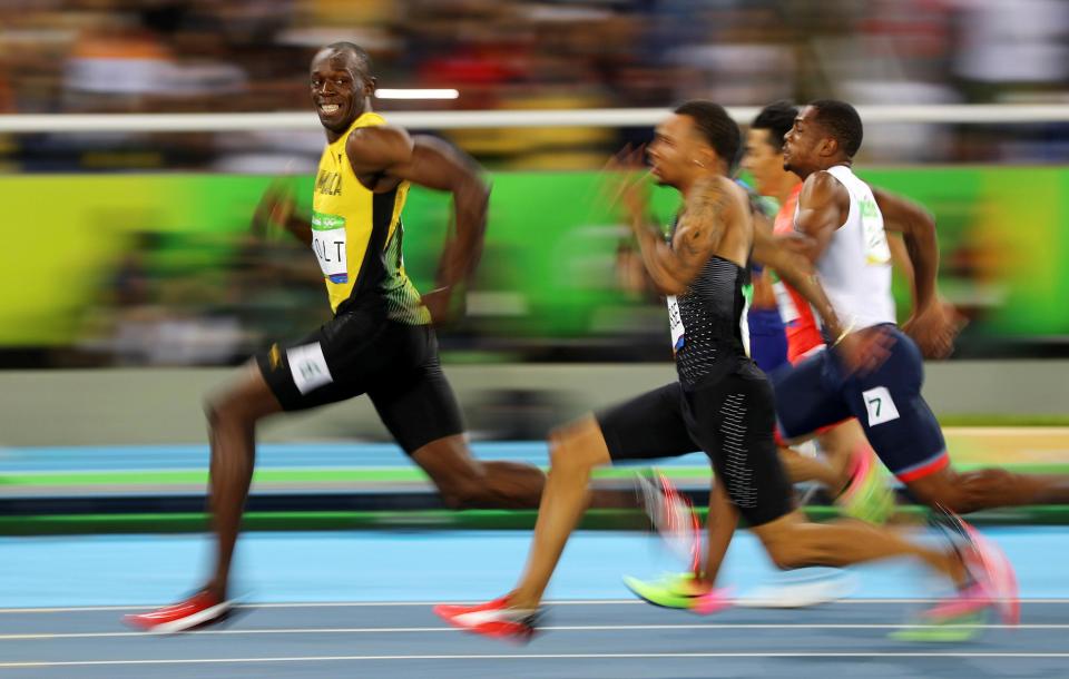  Bolt smiles across at rival Andre De Grasse during the 100m semi-final in Rio