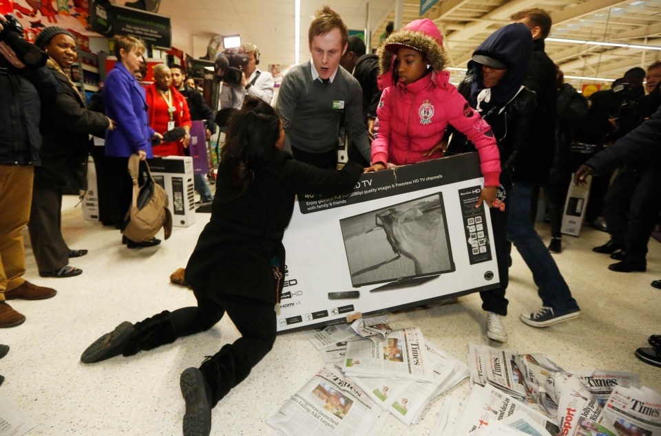 Shoppers wrestle over a television as they compete to purchase retail items on Black Friday at an Asda superstore in Wembley