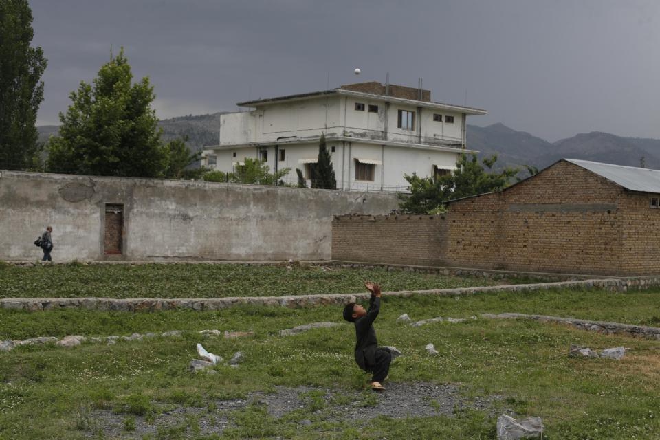  A boy plays with a tennis ball in front of the compound where US Navy SEAL commandos killed Al-Qaeda leader Osama bin Laden