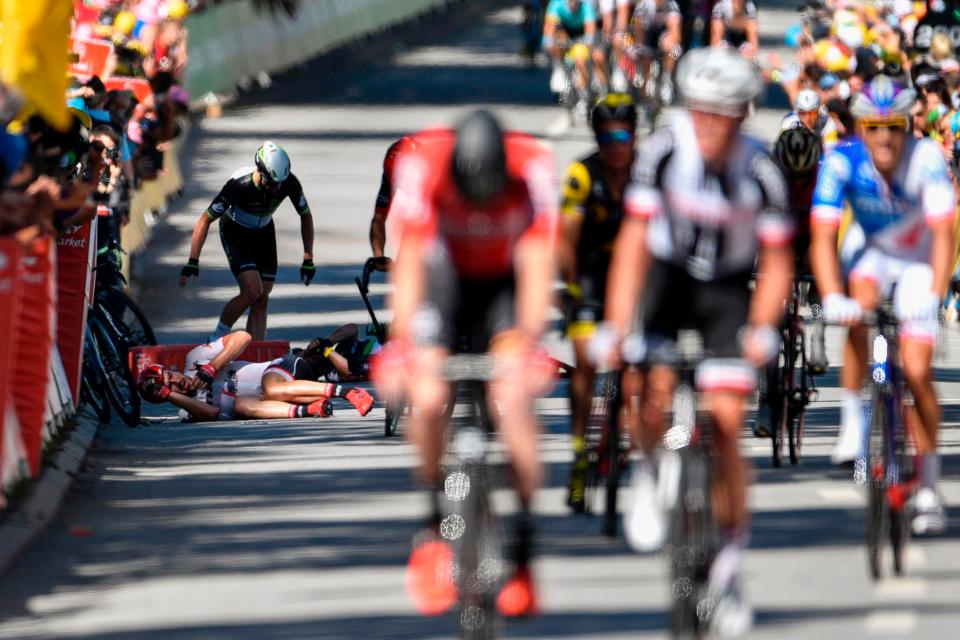  Mark Cavendish's team-mates rush to his aid as riders complete their final sprint in Vittel