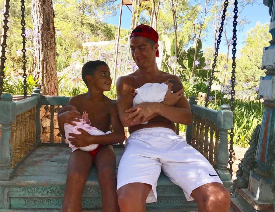  Cristiano Ronaldo sits with son Cristiano Ronaldo Jr and his newborn twins