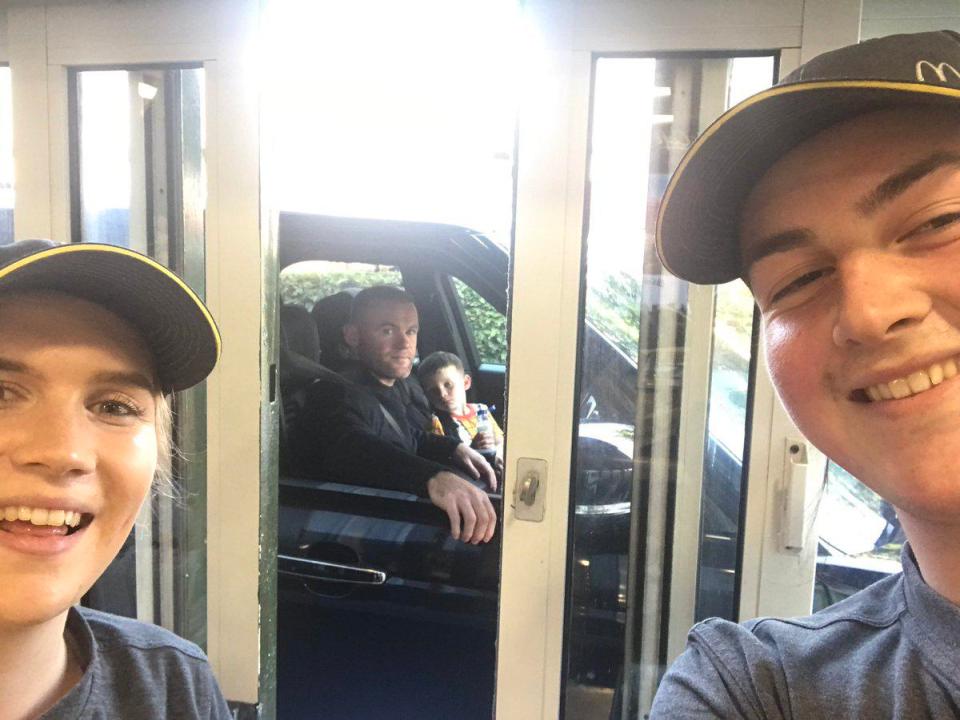  Two McDonald's workers pose for a photo as footballer Wayne Rooney rocks up to the drive-thru window