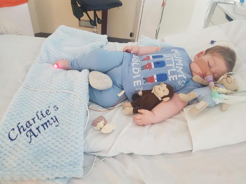  Charlie, pictured in hospital today, wearing a 'Mummy's Little Soldier' t-shirt and next to a 'Charlie's Army' blanket