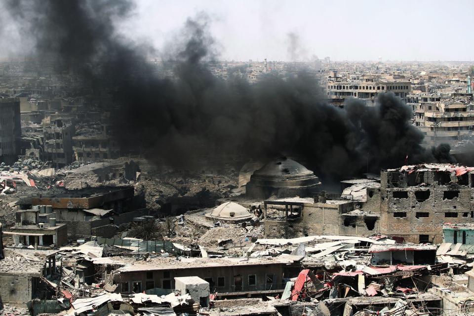  Dark smoke floats over the blackened ruins of Mosul, northern Iraq after months of fighting 