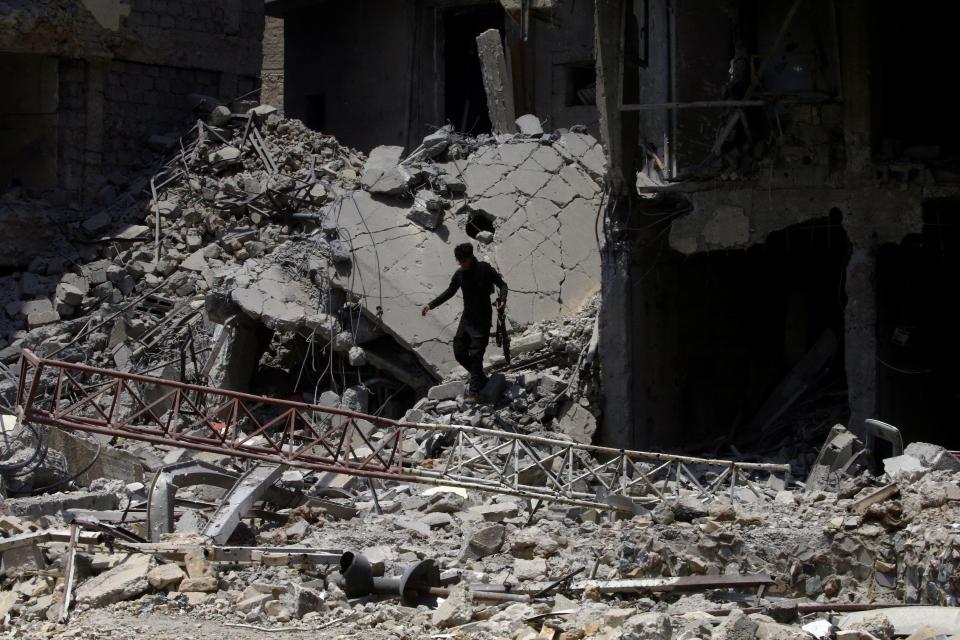  Iraqi security forces walk along destroyed buildings from clashes in the Old City of Mosul