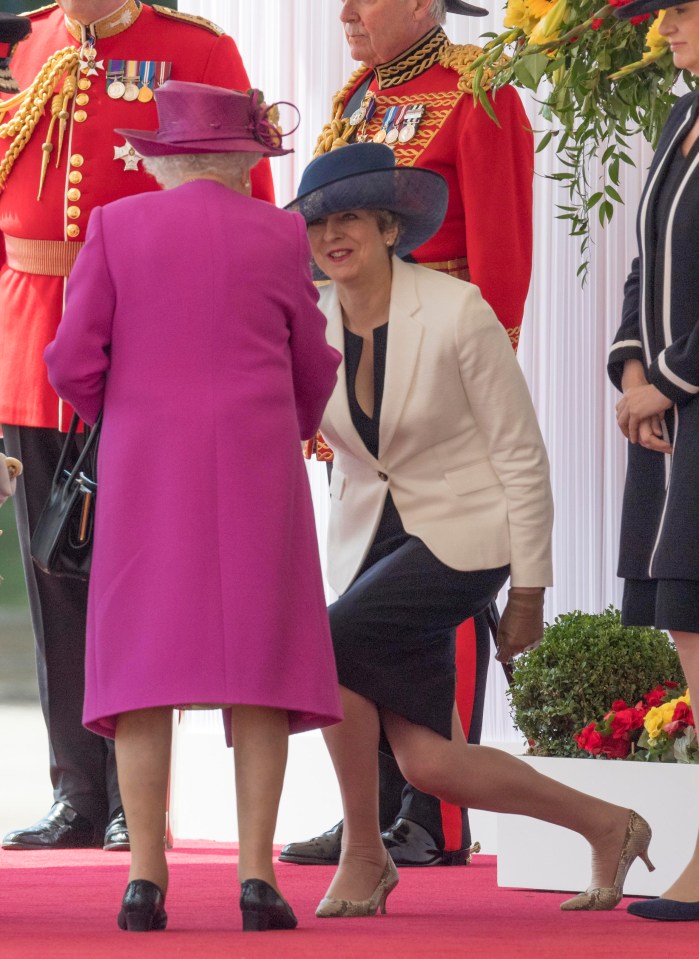 Prime Minister Thersa May curtsies to The Queen before meeting King Felipe