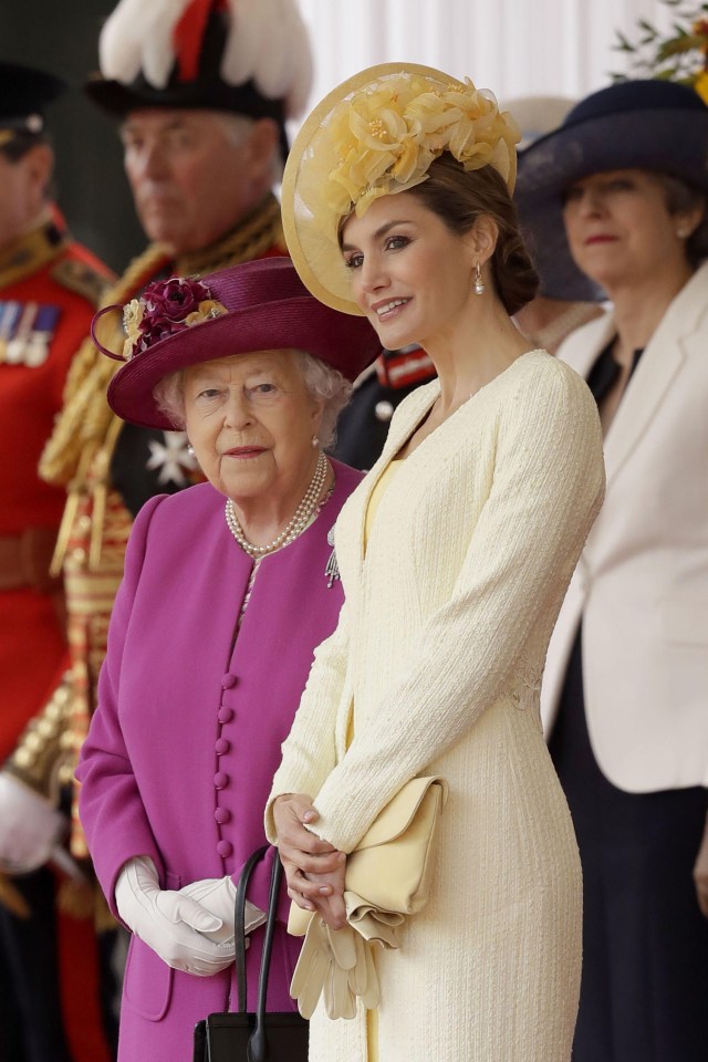 Spain’s Queen Letizia stands with Queen Elizabeth as their husbands King Felipe and Prince Philip inspect an honour guard during a ceremonial welcome