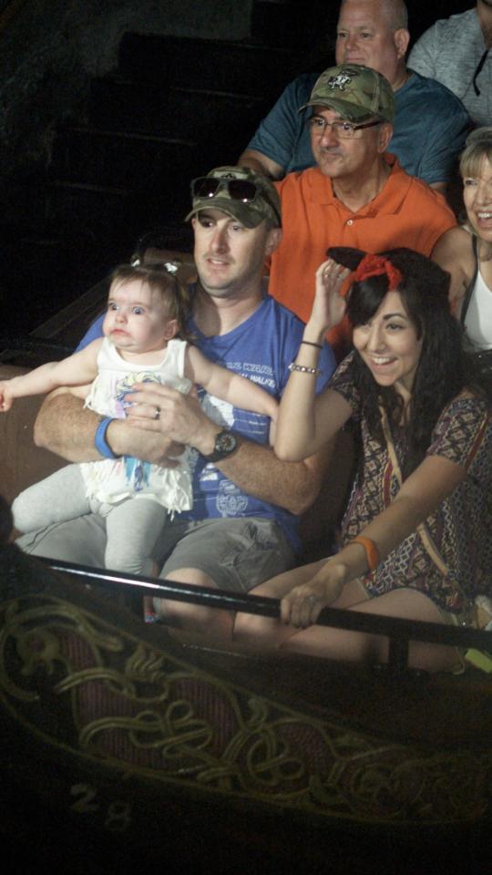  The youngster's father held her on the ride, while seated next to his partner who was dressed in Minnie Mouse ears