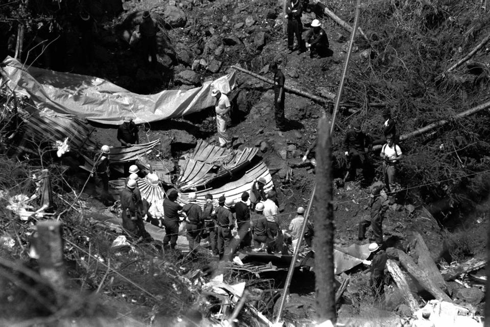  Members of the crash investigation team check the debris of the aft pressure bulkhead at the crash site at the ridge of Mount Osutaka