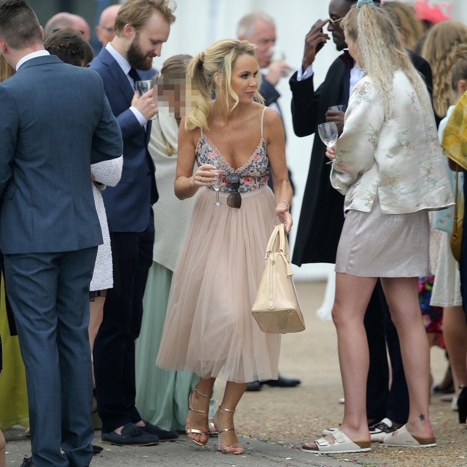 Amanda Holden looks in excellent spirits while ­cradling a champagne flute during a friend’s wedding