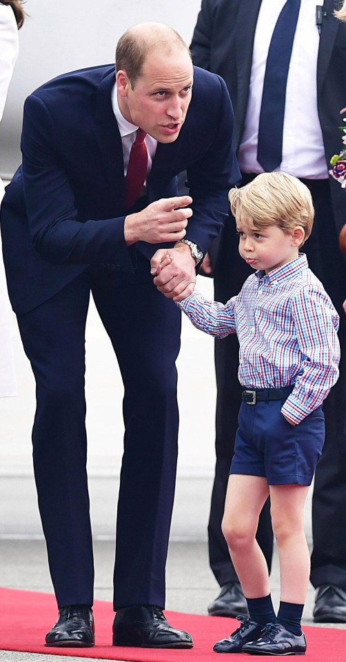 A smartly dressed Prince George looks bored as he stands with dad on a red carpet