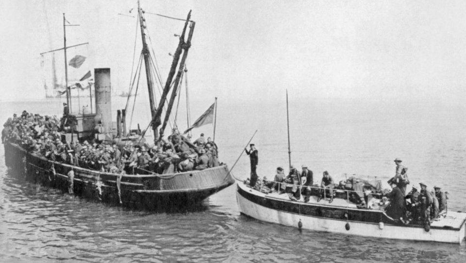  A motor launch laden with rescued British heroes follows a small tug back to British shores