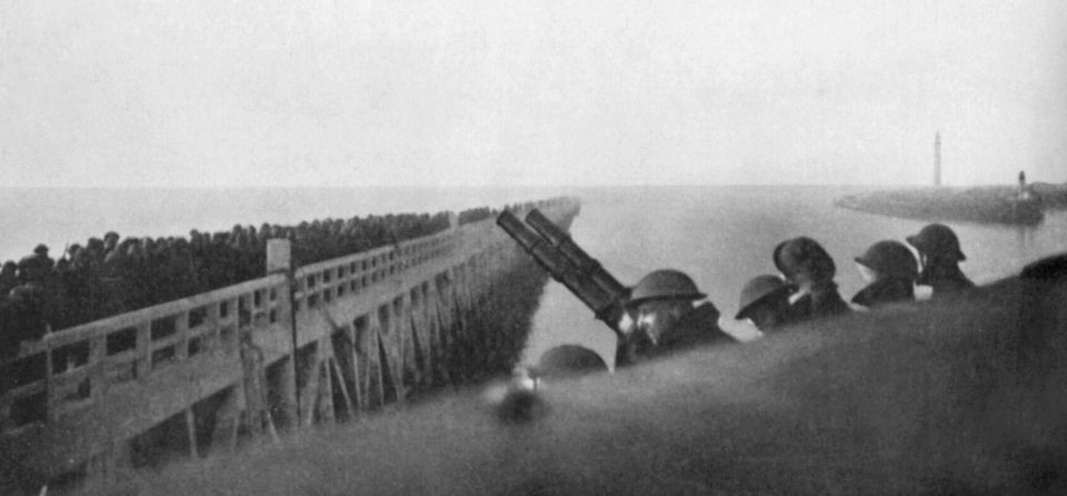  Dunkirk pier is crammed full of troops with one clutching a double-barrelled machine gun