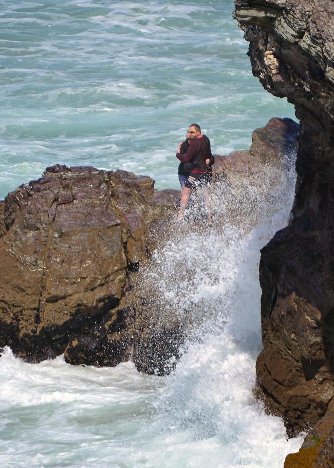  Couple cling to each other for dear life as they are cut off by the tide in Cornwall