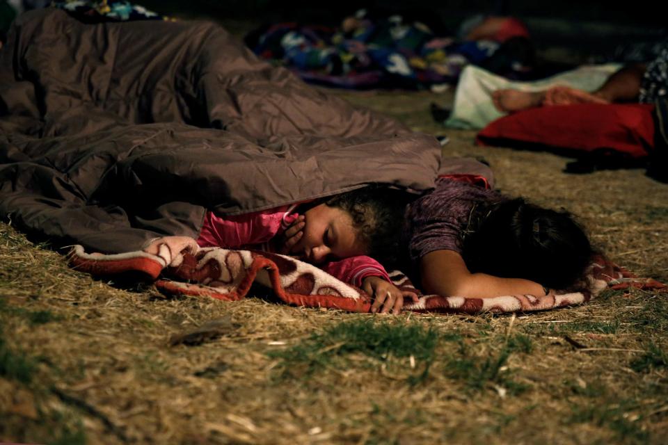 Children sleep in a park after an earthquake off the island of Kos