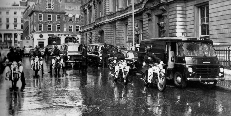 A huge police guard as the Krays arrive for an appearance at Bow Street Magistrates Court in central London