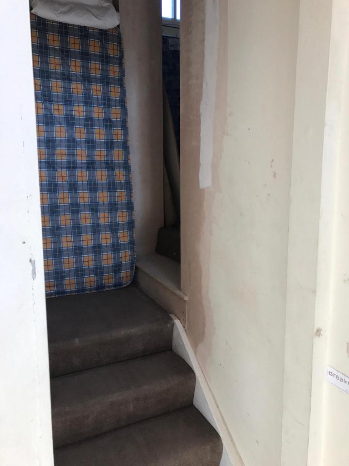  A mattress is seen here propped up against walls in need of a paint