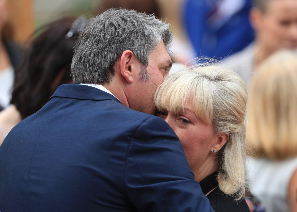 Dad Andrew embraced his wife Lisa after the service in which he had paid an emotional tribute to his daughter