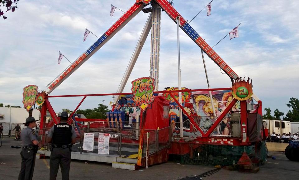  Authorities stand near the Fireball amusement ride after it malfunctioned injuring several at the Ohio State Fair