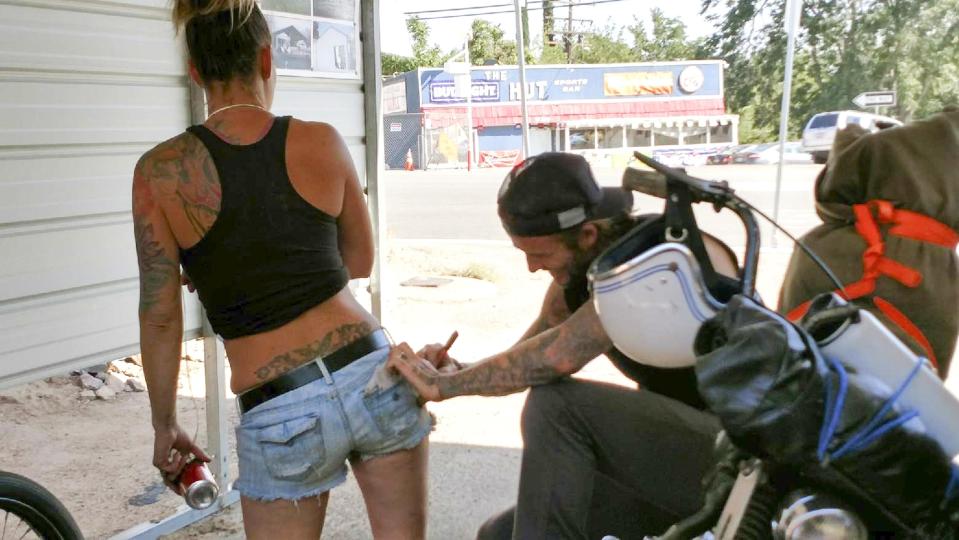  David Beckham shared a cheeky moment with one lucky female fan in California - signing his name onto her bum