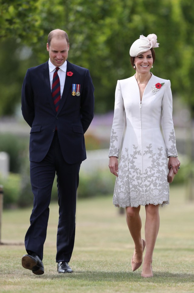 William, wearing his medals, smiles as he walks through the graveyard with Kate this morning