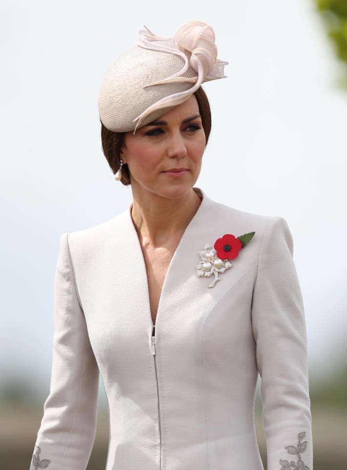 Kate looks solemn as she walks through the cemetery donning a red poppy