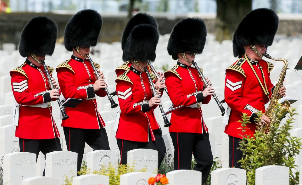 Musicians in the Irish Guards parade through Tyne Cot cemetery