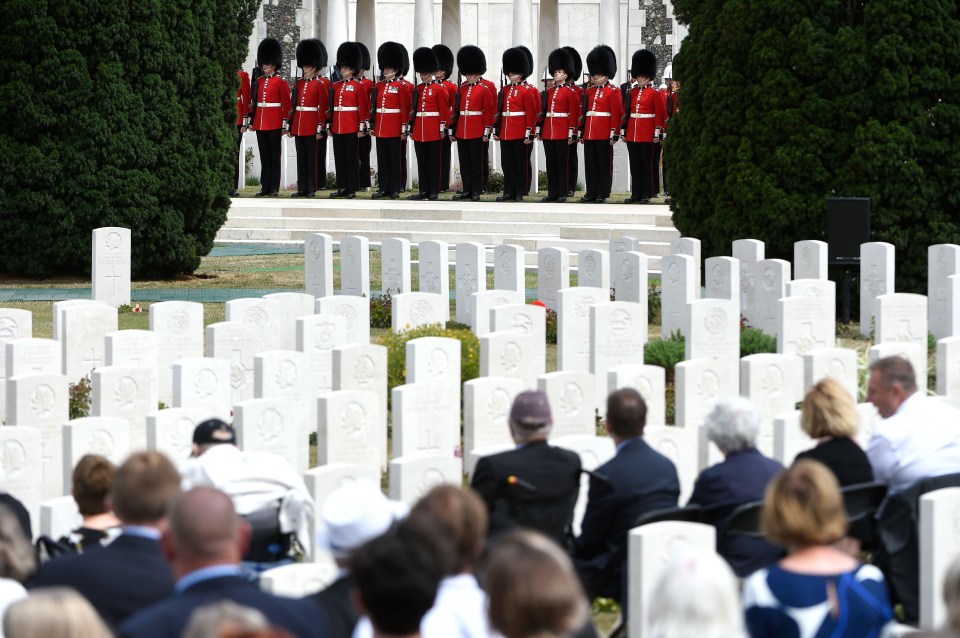 Irish Guards stand to attention as visitors look over the graves today 