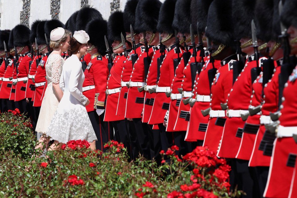 Kate and Queen Mathilde walk towards a row of Irish Guards at Tyne Cot today