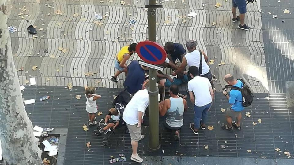  Pedestrians crowd around a bystander injured in the incident