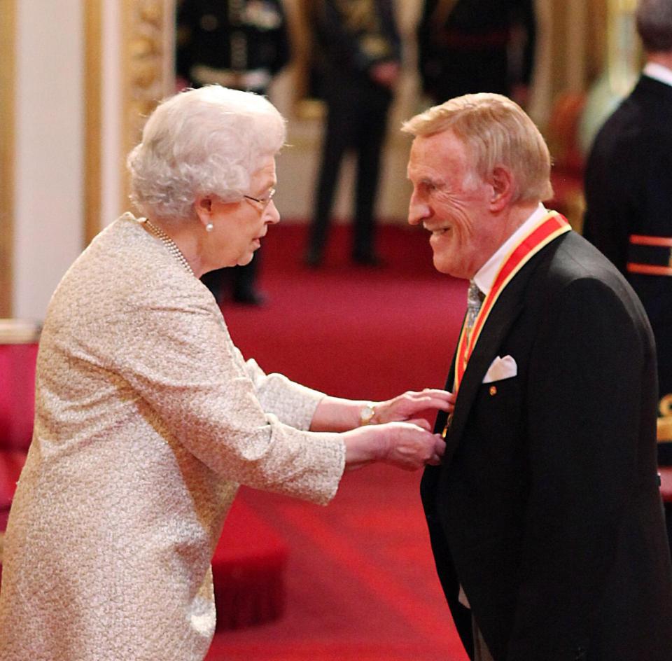  Sir Bruce Forsyth being knighted by the Queen at Buckingham Palace in 2011