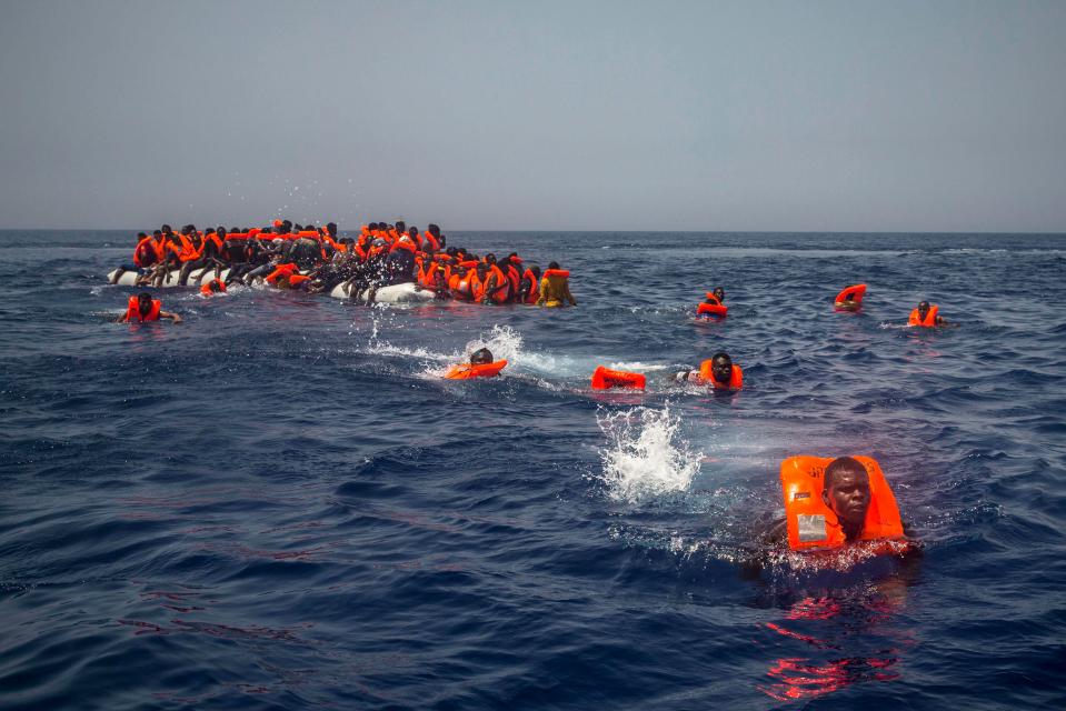  African migrants swim toward a Spanish rescue boat after their rubber boat began to leak in the Med north of Libya