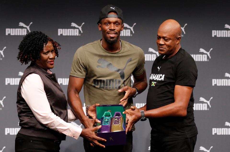  Bolt shows off his running shoes with his parents, Jennifer and Wellesley