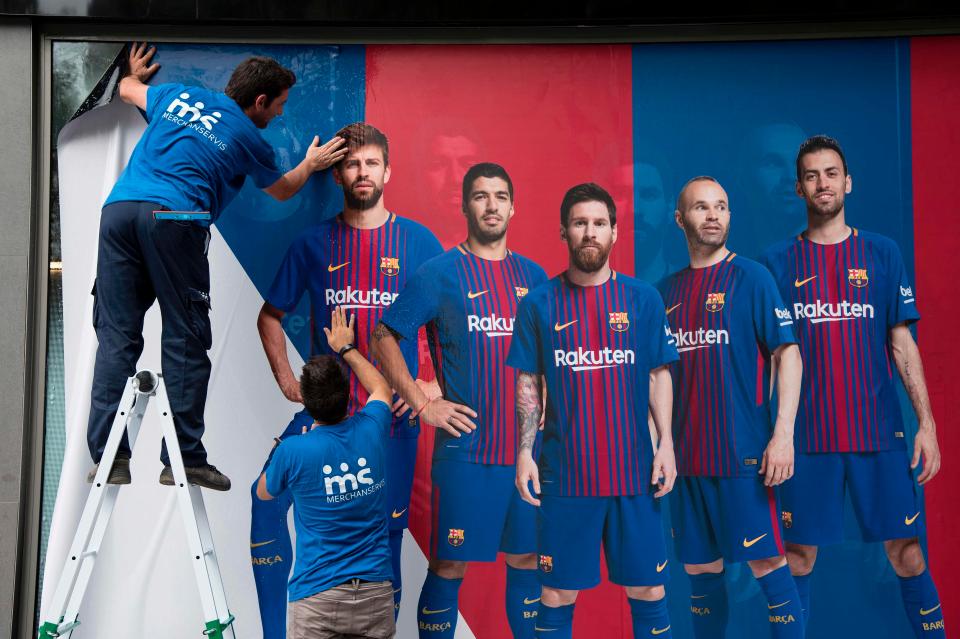  A worker places a new poster up at the Nou Camp in place of a Neymar picture