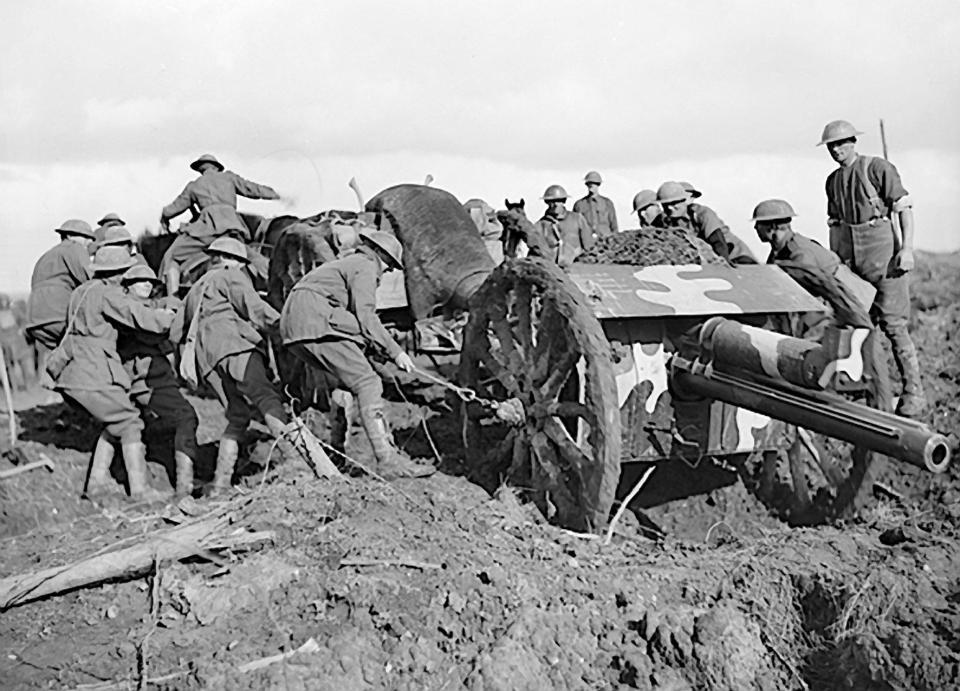  Men struggle to move an artillery gun across the battlefield