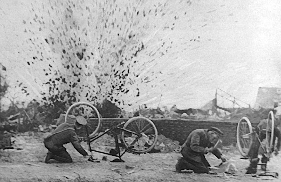  The Cyclist Corps troops try to fix their bikes as a shell explodes just a few feet away from them