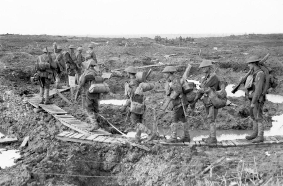  Infantry head across a duckboard track, laid down on the muddy ground