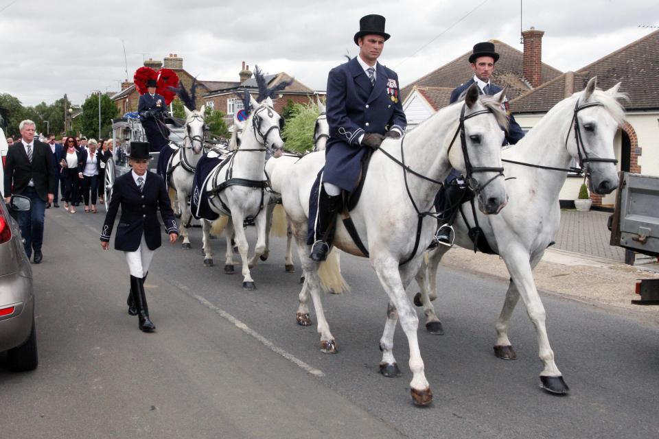  Six white horses walked ahead of the young man's coffin as it was carried to the cemetery