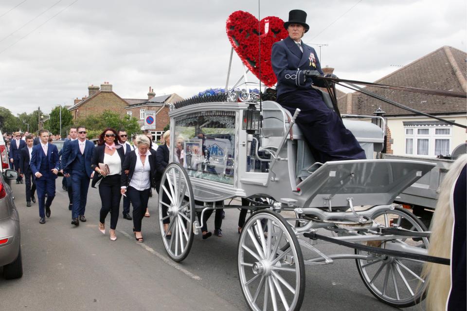  Mourners joining the funeral procession make their way towards the cemetery