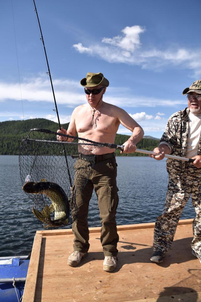  Vladimir Putin reels in the thrashing fish before bagging it in his net