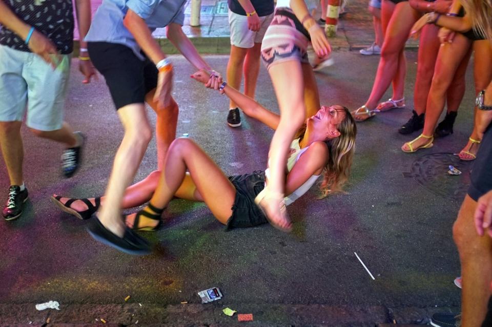  A young woman is helped to her feet by a pal during a night out in Magaluf, where mainly of the problems are fuelled by cheap booze